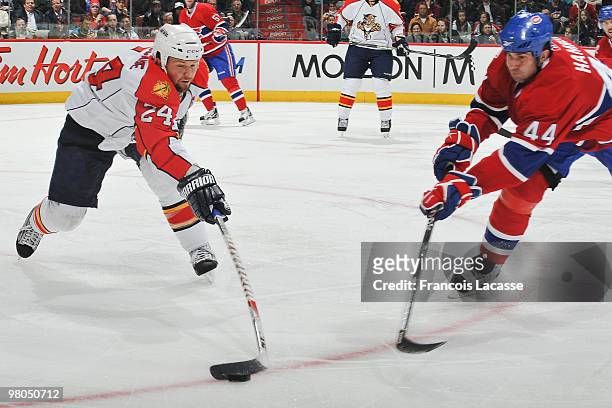 Bryan McCabe of the Florida Panthers battles for the puck with Roman Hamrlik of the Montreal Canadiens during the NHL game on March 25, 2010 at the...