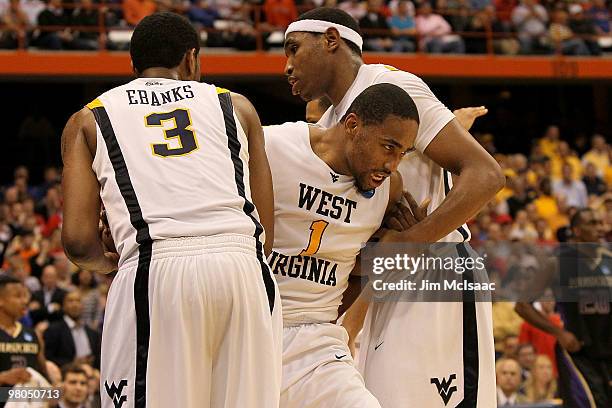 Da'Sean Butler of the West Virginia Mountaineers is helped up by teammates Devin Ebanks and Kevin Jones after Butler took a hard fall in the second...