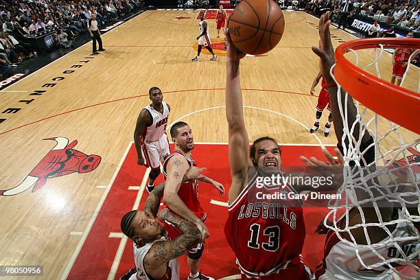 Joakim Noah of the Chicago Bulls attempts a dunk against Jermaine O'Neal of the Miami Heat on March 25, 2010 at the United Center in Chicago,...