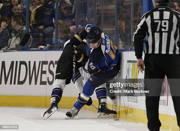 Andy McDonald of the St. Louis Blues is checked by Wayne Simmonds of the Los Angeles Kings on March 25, 2010 at Scottrade Center in St. Louis,...