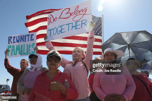 Linda Posada holds up a sign that reads, ' we belong together,' as mayors with the U.S. Conference of Mayors speak at the Tornillo-Guadalupe port of...