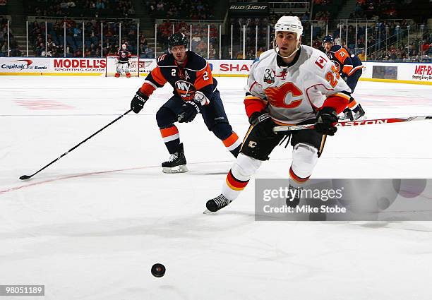 Eric Nystrom of the Calgary Flames and Mark Streit of the New York Islanders pursue a loose puck on March 25, 2010 at Nassau Coliseum in Uniondale,...