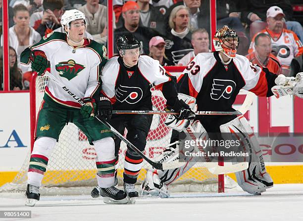 Oskars Bartulis of the Philadelphia Flyers defends against James Sheppard of the Minnesota Wild in front of goaltender Brian Boucher on March 25,...