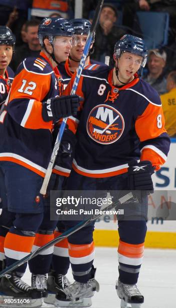 Josh Bailey of the New York Islanders congratulates teammate Bruno Gervais on his goal in the third period of an NHL game against the Calgary Flames...