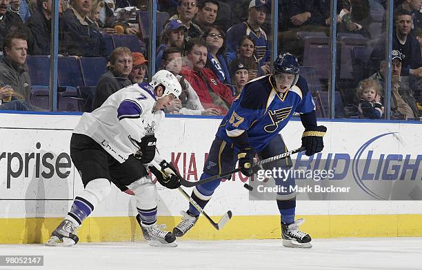 Rob Scuderi of the Los Angeles Kings battles for the puck with David Perron of the St. Louis Blues on March 25, 2010 at Scottrade Center in St....