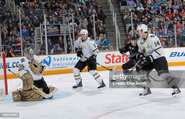 Logan Couture of the San Jose Sharks follows the puck shot through Nicklas Grossman and Jamie Benn of the Dallas Stars to goalie Marty Turco during...