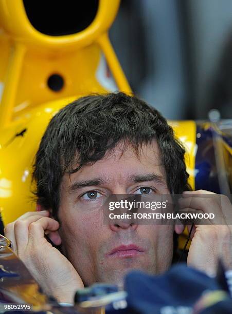 Red Bull Racing's Mark Webber of Australia puts in his earplugs for the first practice session of Formula One's Australian Grand Prix in Melbourne on...