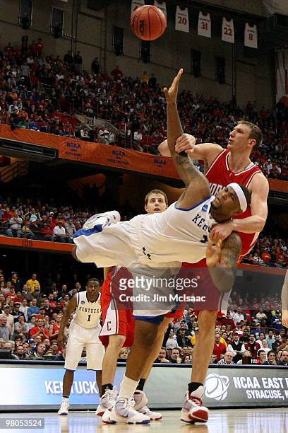 DeMarcus Cousins of the Kentucky Wildcats is fouled as he attempts a shot by Jeff Foote of the Cornell Big Red during the east regional semifinal of...