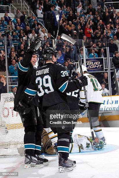 Dany Heatley congratulates teammate Logan Couture of the San Jose Sharks on his third period goal during an NHL game against the Dallas Stars on...