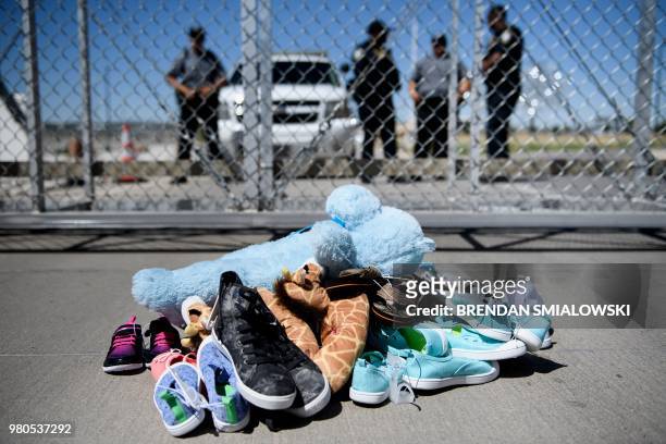 Security personal stand before shoes and toys left at the Tornillo Port of Entry where minors crossing the border without proper papers have been...