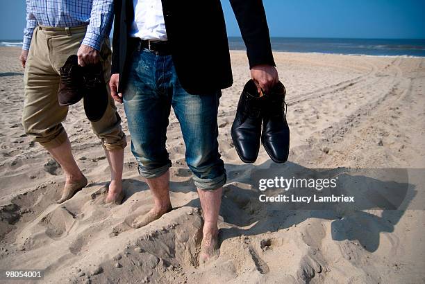 business men on the beach - lucy lambriex stock-fotos und bilder