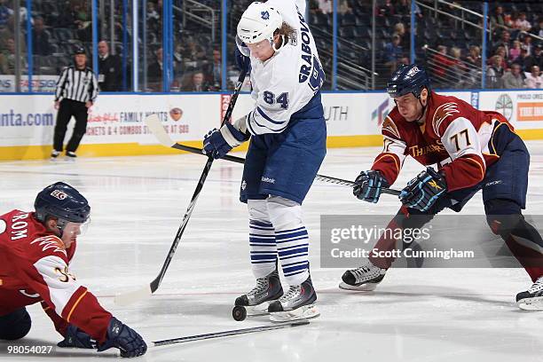 Mikhail Grabovski of the Toronto Maple Leafs battles for the puck against Pavel Kubina and Tobias Enstrom of the Atlanta Thrashers at Philips Arena...