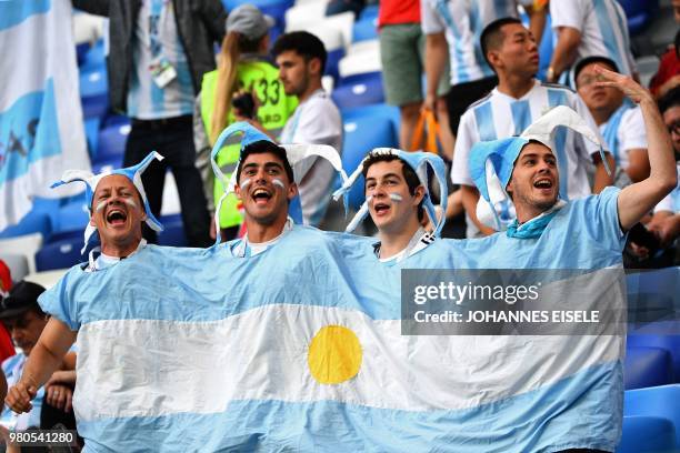 Four Argentina's fan wear a one-piece tshirt representing their national flag as they wait in the grandstand before the Russia 2018 World Cup Group D...