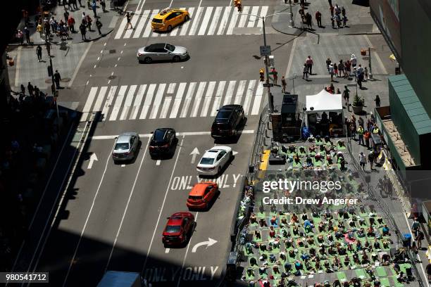 Yoga enthusiasts participate in a mass yoga class in Manhattan's Times Square to celebrate the summer solstice and mark World Yoga Day, June 21, 2018...