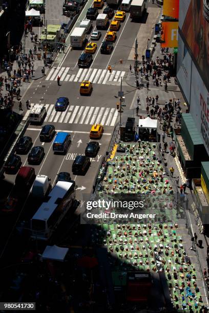 Yoga enthusiasts participate in a mass yoga class in Manhattan's Times Square to celebrate the summer solstice and mark World Yoga Day, June 21, 2018...