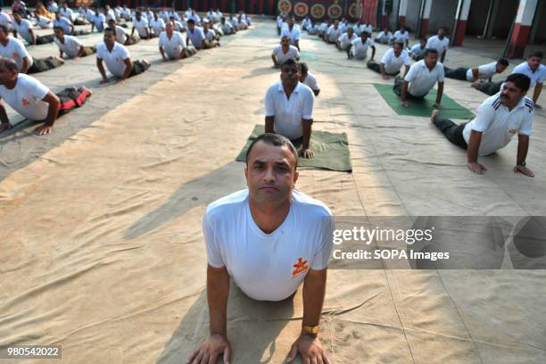 Members of the military force stretching out on their bellies during the yoga session. Soldiers of paramilitary force doing yoga on the occasion of...