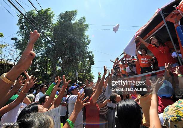 Imee marcos , daughter of Philippine former first lady Imleda Marcos, who is running for governor in the general election, throws free teeshirts to...