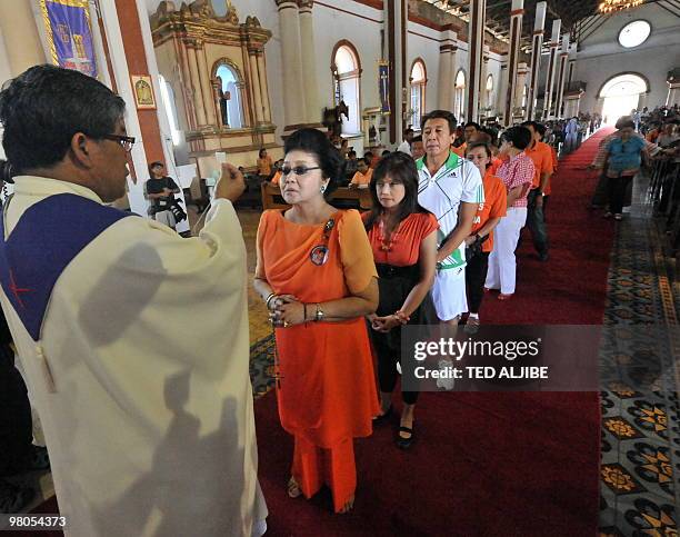 Philippines former first Lady Imelda Marcos receives communion while attending mass at a church prior to a campaign sortie in the town of Paoay,...