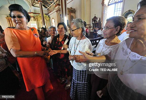 Philippines former first Lady Imelda Marcos greets supporters during a mass at a church prior to a election campaign sortie in the town of Paoay,...