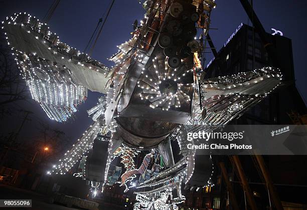 An illuminated Phoenixe, one of Xu Bing's towering sculptural masterpiece 'The Phoenixes', is see at the square of Today Art Museum on the...