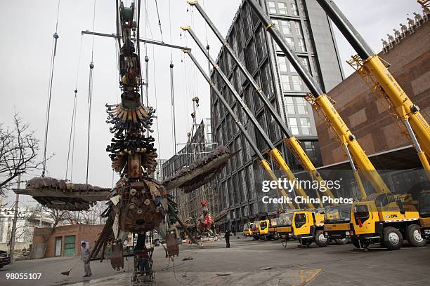 Phoenixe, one of Xu Bing's towering sculptural masterpiece 'The Phoenixes', is lifted at the square of Today Art Museum on the preparation for its...