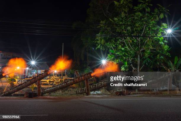 traditional cannon made from coconut palm tree light up during the celebration of eid-mubarak. - shaifulzamri stock pictures, royalty-free photos & images