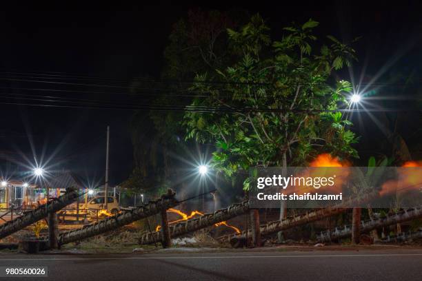 traditional cannon made from coconut palm tree light up during the celebration of eid-mubarak. - shaifulzamri - fotografias e filmes do acervo