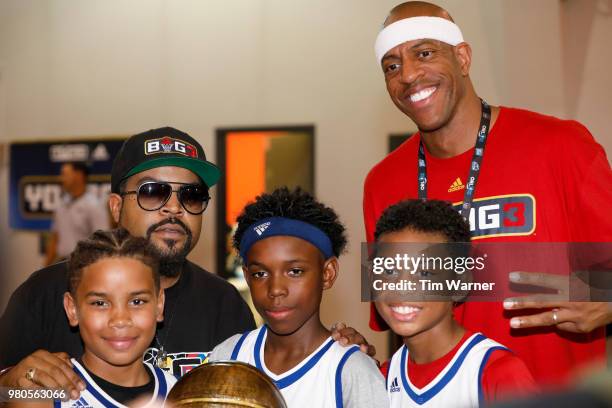 Rap Artist Ice Cube and Jerome Williams pose for a photograph with tournament champions during the Young3 Basketball Clinic and Tournament on June...