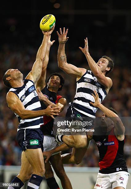 Brad Ottens and Cameron Mooney of the Cats compete for the ball against Patrick Ryder of the Bombers during the round one AFL match between the...