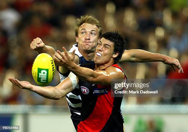 Angus Monfries of the Bombers competes with Darren Milburn of the Cats during the round one AFL match between the Geelong Cats and the Essendon...