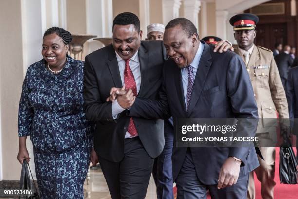 Kenya's President Uhuru Kenyatta and Ethiopia's Foreign Minister Workneh Gebeyehu react before the 32nd Extraordinary Summit of Intergovernmental...