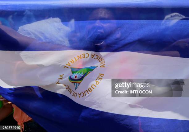Woman behind a Nicaraguan flag shouts slogans in Monimbo neighbourhood, in Masaya some 35km from Managua on June 21, 2018. - Nicaraguan bishops...