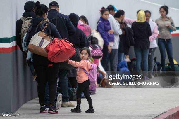 Migrants line up at El Chaparral port of entry in Tijuana, Mexico, in the boder with the United States on June 21, 2018. - US lawmakers were poised...