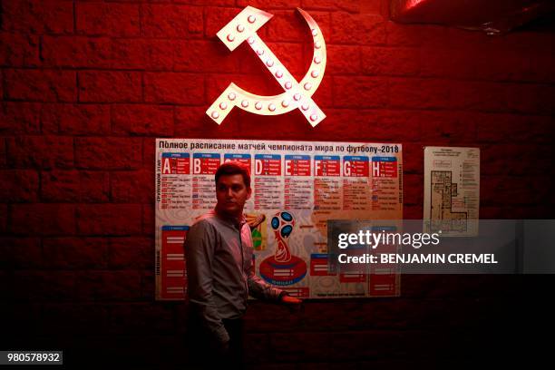 Man walks past a hammer and a sickle adorning a wall in Kazan on June 21, 2018 during the Russia 2018 World Cup football tournament.