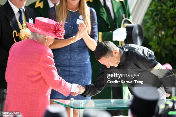 Queen Elizabeth II presents Frankie Dettori with his prize after he rode Stradivarius to win The Gold Cup on day 3 at Ascot Racecourse on June 21,...