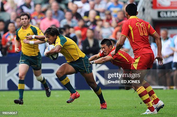 Brakin Karauria-Henry of Australia pulls away from Jin Ye of China during their match on the first day of the Hong Kong Sevens rugby tournament on...