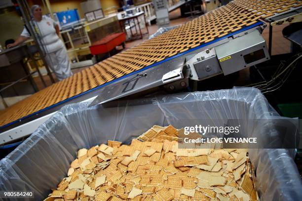 An employee works on the production line of the "Petit Beurre" biscuits at the French biscuit manufacturer LU in La Haye-Fouassiere, near Nantes,...