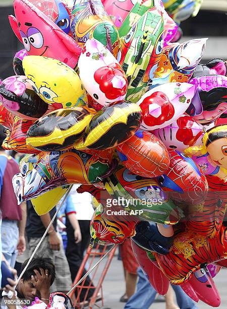 Vendor holds items for sale near the Quiapo Church in Manila on March 26, 2010. AFP PHOTO/NOEL CELIS