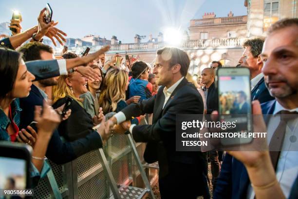 French president Emmanuel Macron shakes hands with people during the annual "Fete de la Musique" in the courtyard of the Elysee Palace, in Paris, on...