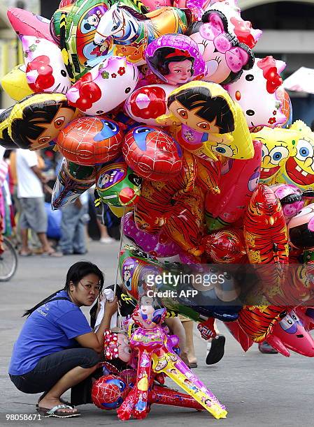 Vendor holds items for sale near the Quiapo Church in Manila on March 26, 2010. AFP PHOTO/NOEL CELIS