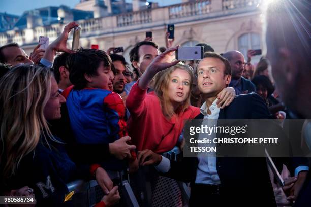 French president Emmanuel Macron poses for pictures with people during the annual "Fete de la Musique" in the courtyard of the Elysee Palace, in...