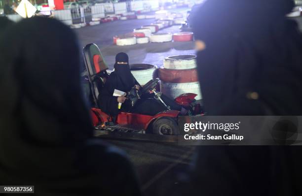 Women wearing the traditional niqab try out driving go-karts at an outdoor educational driving event for women on June 21, 2018 in Jeddah, Saudi...