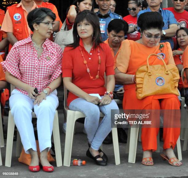 Philippines former first Lady Imelda Marcos sits with her daughters Imee and Irene after attending a mass at a church prior to her campaign sortie in...