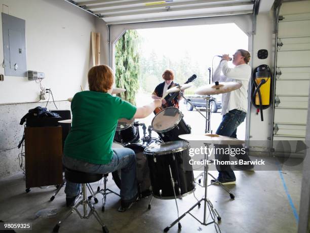 teen garage band playing rearview - grupo de interpretación musical fotografías e imágenes de stock