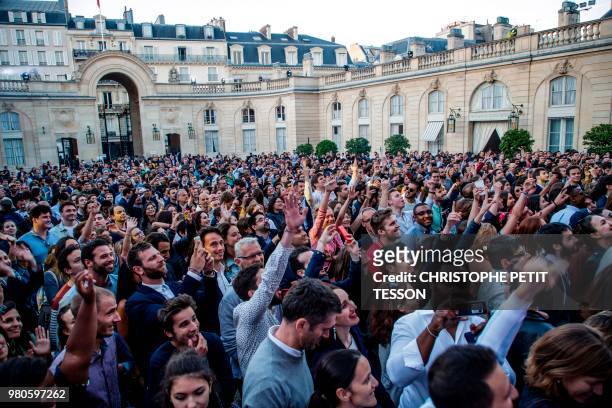 People react as Dj Kiddy Smile performs during the annual "Fete de la Musique" in the courtyard of the Elysee Palace, in Paris, on June 21, 2018.