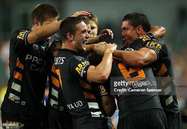 Benji Marshall of the Tigers is congratulated by team mates after scoring a try during the round three NRL match between the West Tigers and the...