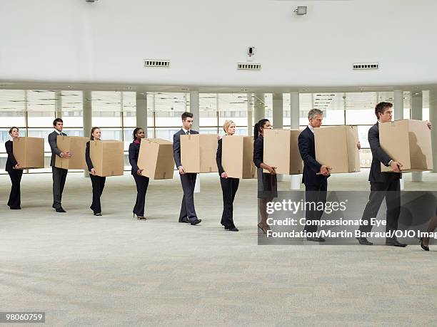 line of business people carrying cardboard boxes - downsizing stock pictures, royalty-free photos & images