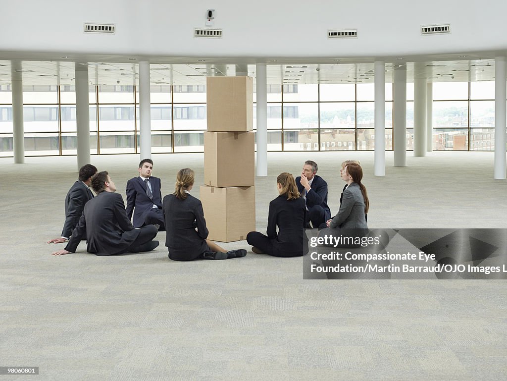 Business people looking at stack of boxes