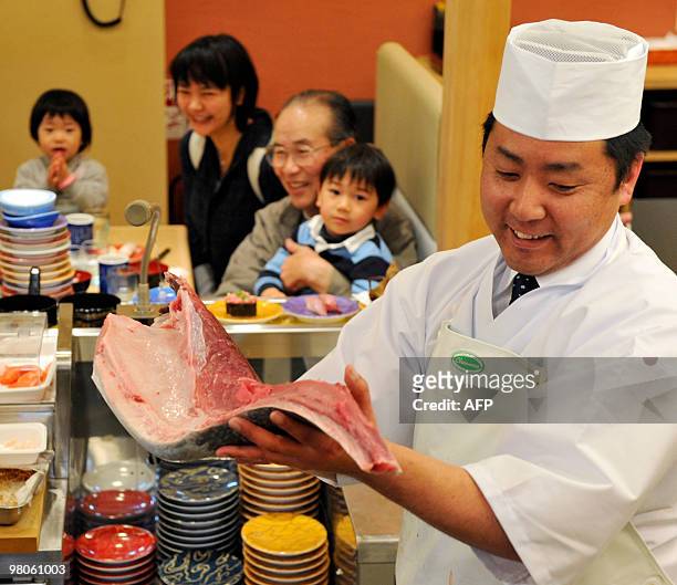 To go with story Species-CITES-UN-Japan-tuna-farm In a picture taken on March 12, 2010 a sushi chef holds up bluefin tuna fillet at a sushi...