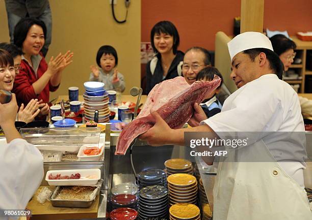 To go with story Species-CITES-UN-Japan-tuna-farm In a picture taken on March 12, 2010 a sushi chef holds up bluefin tuna at a sushi restaurant in...